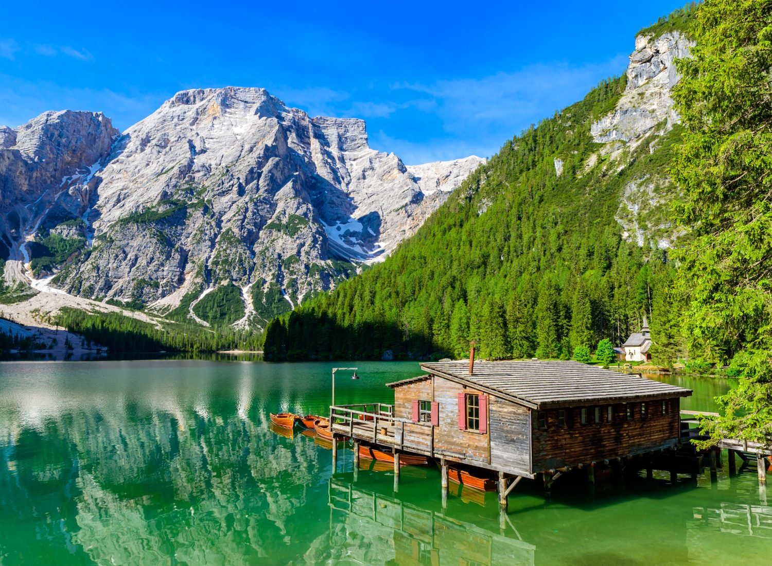 Lake Braies (also known as Pragser Wildsee or Lago di Braies) in Dolomites Mountains, Sudtirol, Italy. Romantic place with typical wooden boats on the alpine lake. Hiking travel and adventure. Pragsee