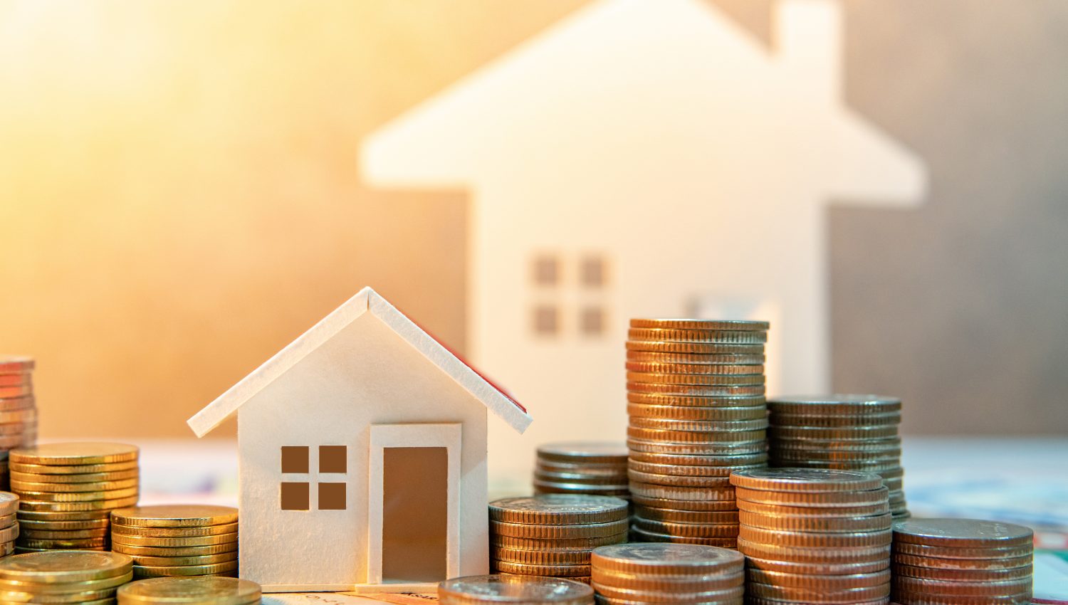 Real estate or property investment. Home mortgage loan rate. Saving money for retirement concept. Coin stack on international banknotes with house model on table. Business growth background Geld vor einem Modelhaus